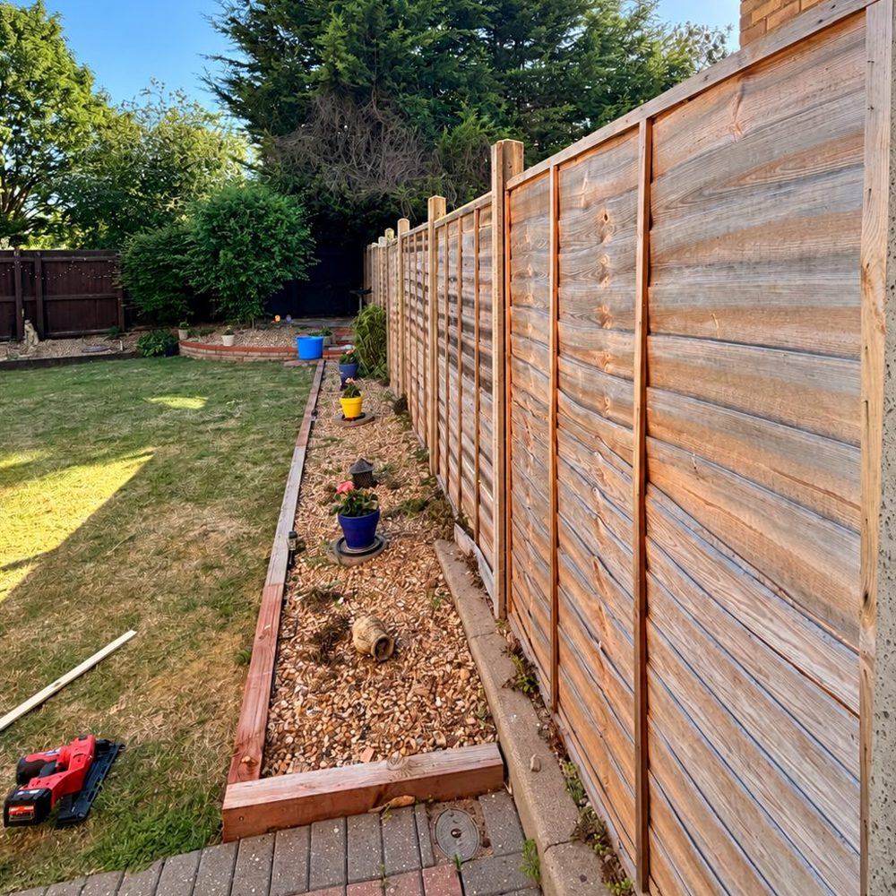 New fence panels and posts installed along a garden boundary