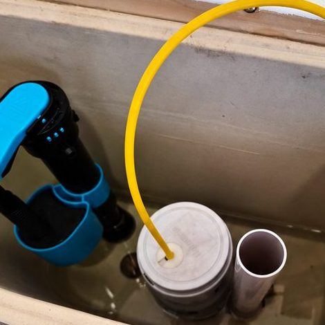 New fill and flush valves fitted inside a toilet cistern